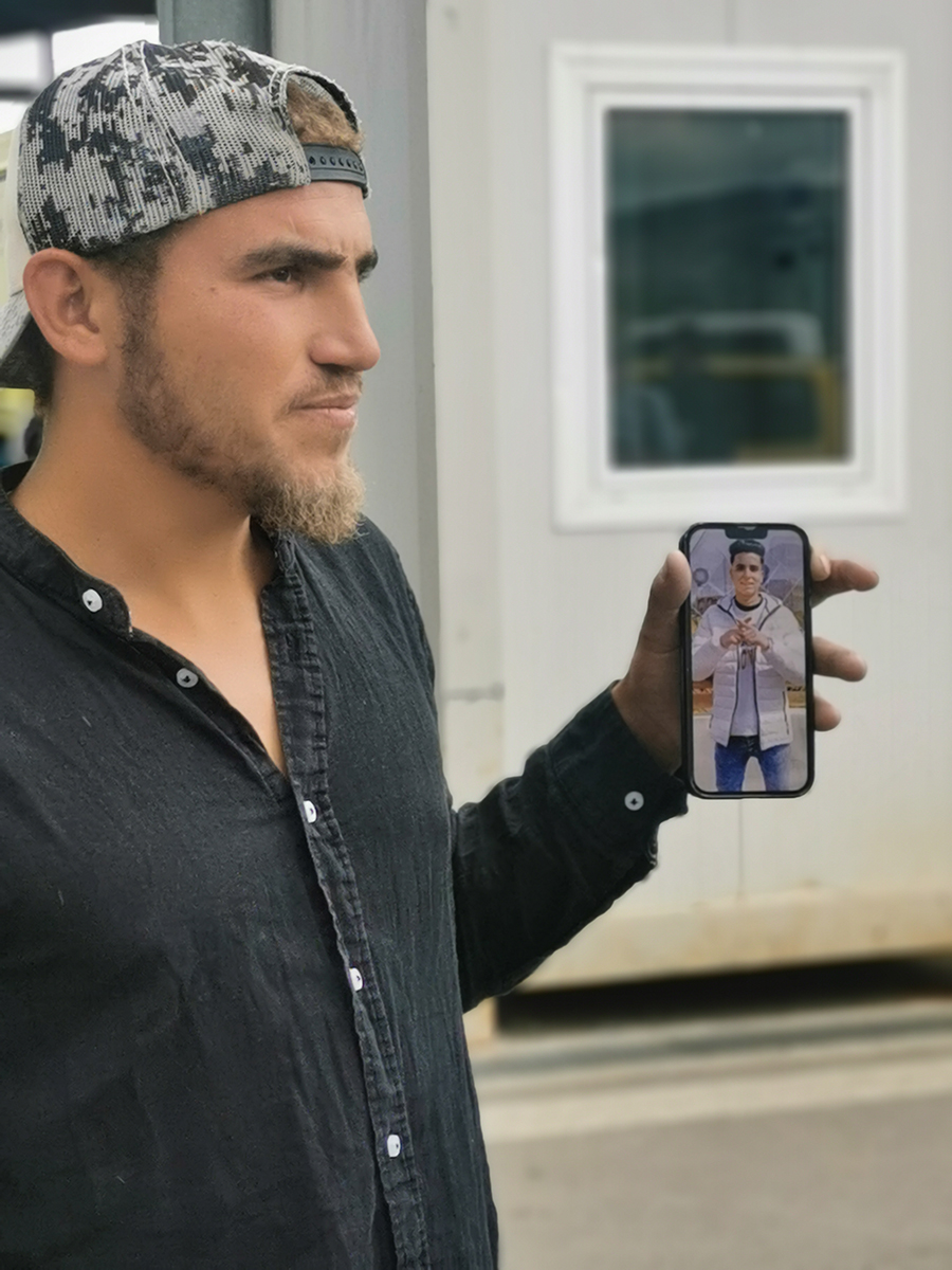 Karim, de nacionalitat egípcia, ensenya una foto del seu veí a la premsa per intentar localitzar-lo