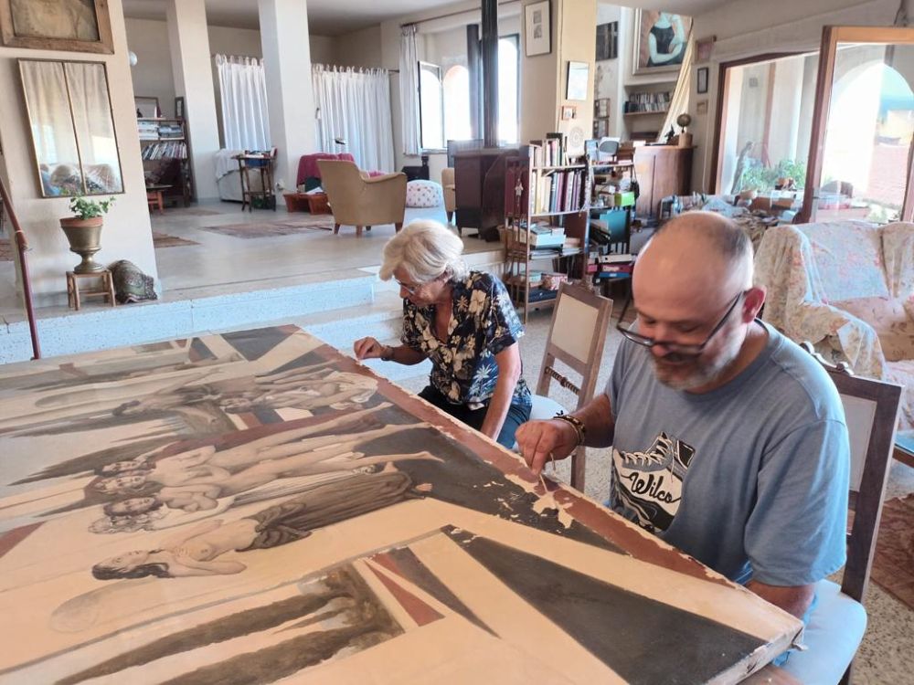 Joan Vissi i Ángeles Sánchez, durant la restauració del quadre a la Bisbal