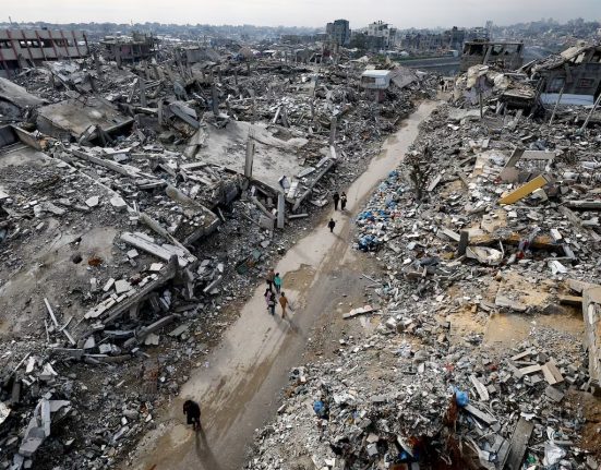 Palestins caminant entre runes a Jabalia, a la franja de Gaza